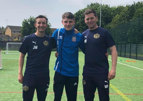 Zak Turner-Cooke, centre, with SSFC head of youth performance and development Jamie Williams, left, and youth performance and development manager Wess Brown, right.