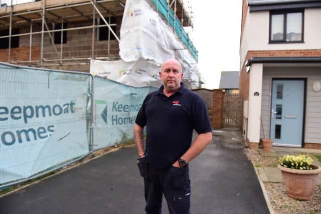 Mark Steele, outside his home, which is next to the scaffolding which has now been covered.