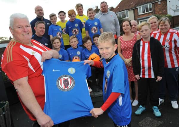 Caer Urfa Sunderland Supporters branch chairman Billy Wilkinson hands over new strips to Harton and Westoe Minors under 10's football team.