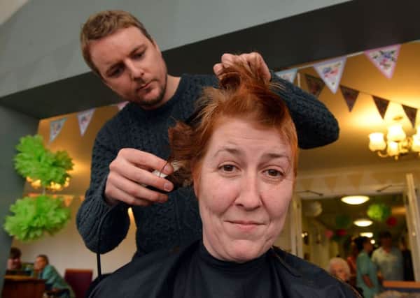 Hairdresser Peter March sets to work on Sarah Rice for her charity headshave.