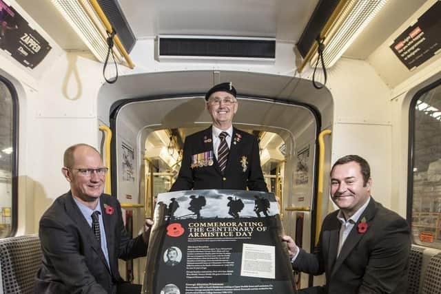 Nexus customer services director Huw Lewis, war veteran George Woodall, and Metro services director Chris Carson with the poster
