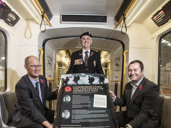 Nexus customer services director Huw Lewis, war veteran George Woodall, and Metro services director Chris Carson with the poster