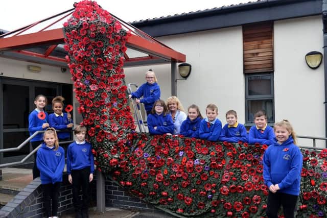Dunn Street Primary school Nursery Nurse Karen Ramshaw (centre) with a selection of pupils alongside their Poppy Display. Picture by FRANK REID