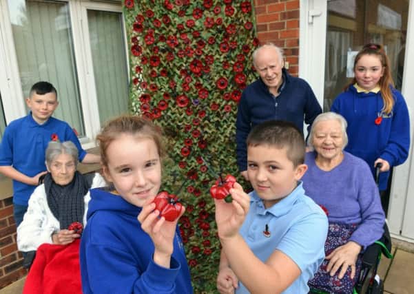 Roseway House Care Home have created a poppy fall. Front, Dunn Hill Street Primary School pupils Morgan Scullion and Dylan Scott. Back from left pupil Kurtis Wilson, resident's Pat Mosley, Jimmy Clinton and Freda Fisher and pupil Ellie Savory