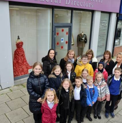John DuckworthFuneral Directors staff Susan Meston and (rear right) Kayren House with staff and pupils from Sea View Primary School in front of the window.