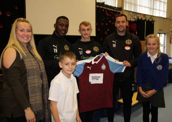 Players Ursene Mouanda, Daniel Wright and Blair Adams present a signed South Shields shirt to Westoe Crown football team captains Jay Brown and Lillie Oliphant, along with PE co-ordinator and Year 6 teacher Kate Bramley.