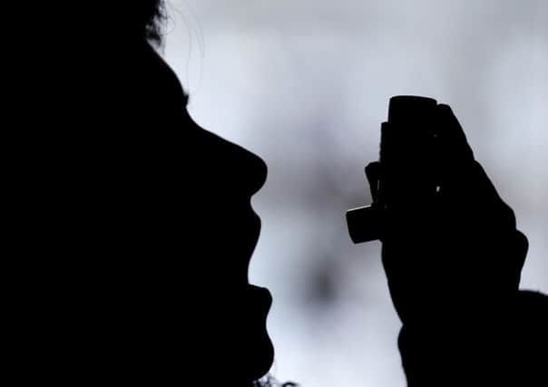 An asthma sufferer uses an inhaler. Pic by PA.