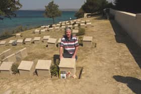 Peter Hoy in front of the  grave of John Simpson Kirkpatrick.
