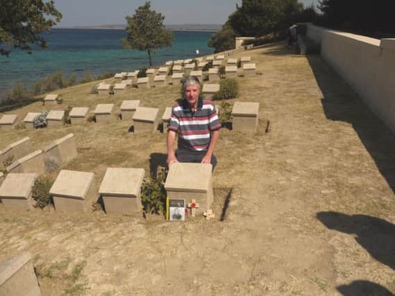 Peter Hoy in front of the  grave of John Simpson Kirkpatrick.