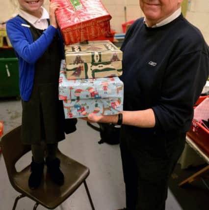 Westoe Crown Primary School pupil Libby with volunteer Ian Currie stacking shoeboxes ready for collection.
