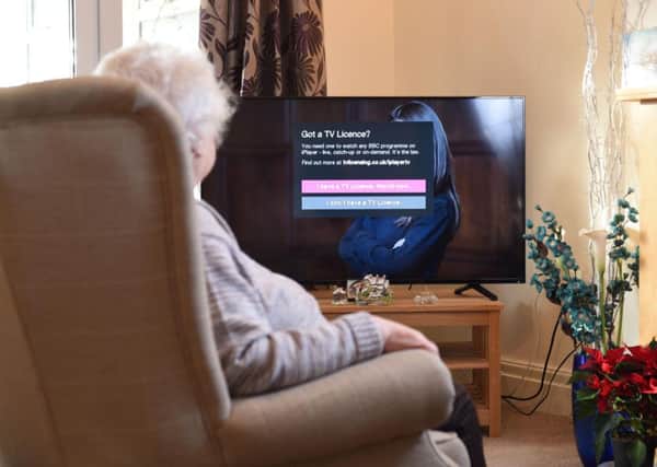 An elderly person watching TV.