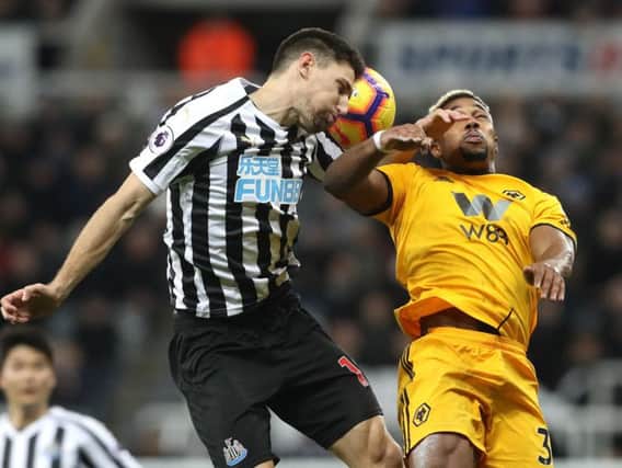 Newcastle's Federico Fernandez challenges for the ball with Adama Traore.