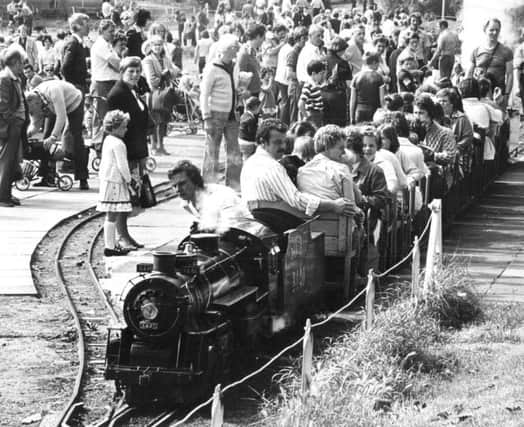 Memory Lane social flow    August 1980  

Bank Holiday crowds at the South Marine Park, watch as a hard worked steam engine takes another load of passengers for a trip around the lake.