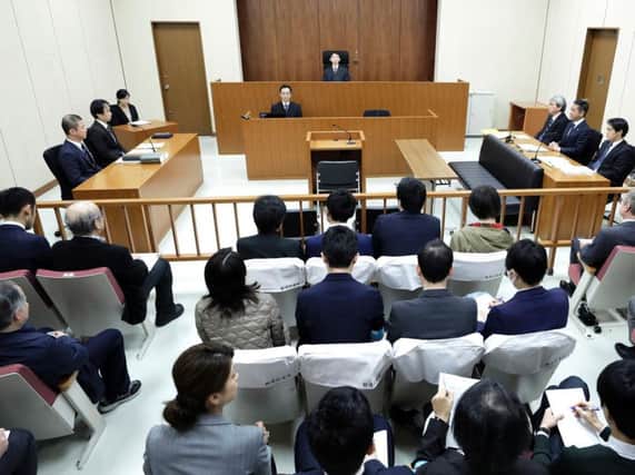 Judge Yuichi Tada, top center, and spectators sit in a courtroom ahead of a court hearing on a case of former Nissan chairman Carlos Ghosn at the Tokyo District Court in Tokyo. Picture: Kiyoshi Ota/Pool Photo via AP.