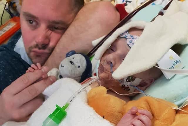 Worried dad Chris Cookson by the bedside of his seriously ill son Carter, who needs a heart transplant.