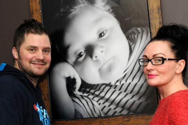 Chris and Sarah Cookson with a picture of their son Charlie.