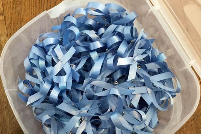 The blue ribbons sold to raise funds.