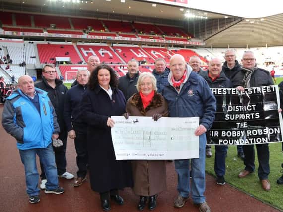 Lady Elsie with representatives of Sids Tours pitchside at the Stadium of Light, after they handed over a donation to the Sir Bobby Robson Foundation.