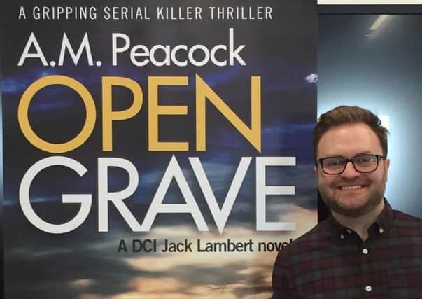 Adam Peacock with his debut novel Open Grave.