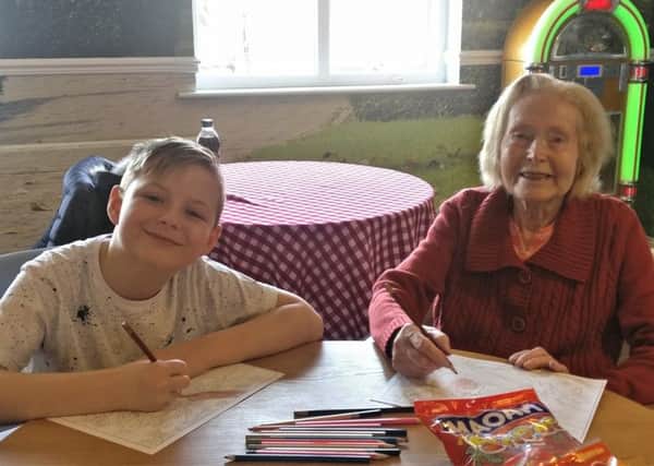 Nine-year-old Jamie Brown and 92-year-old Jessie Hannah create pictures during an arts and crafts session at Willowdene.