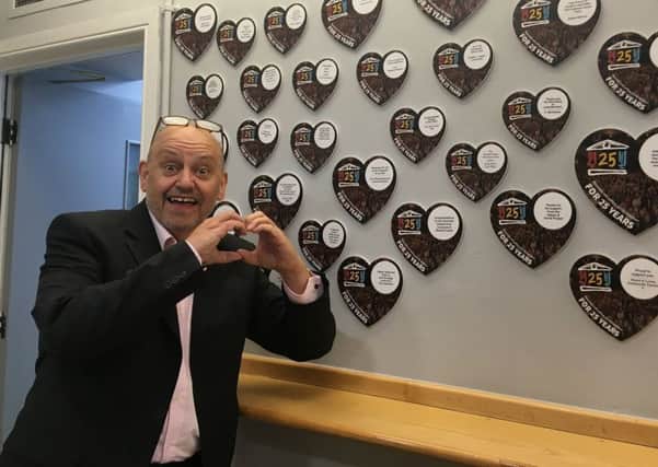 Ray Spencer, executive director of The Customs House, with the growing wall of hearts.