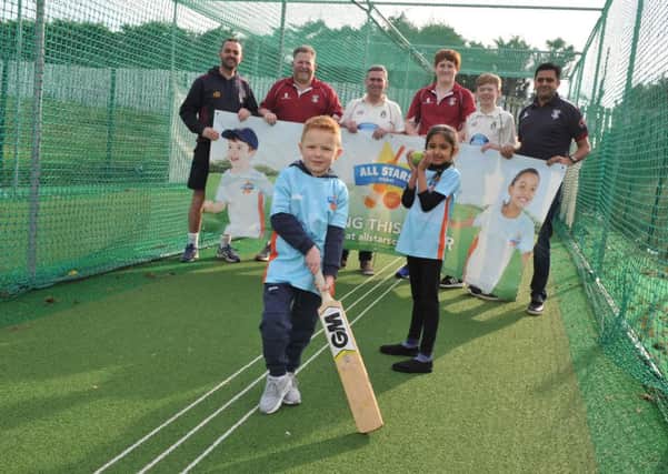 Marsden Cricket Club's All Stars youngsters Harry Mann and Diya Goyal, with club coaches.