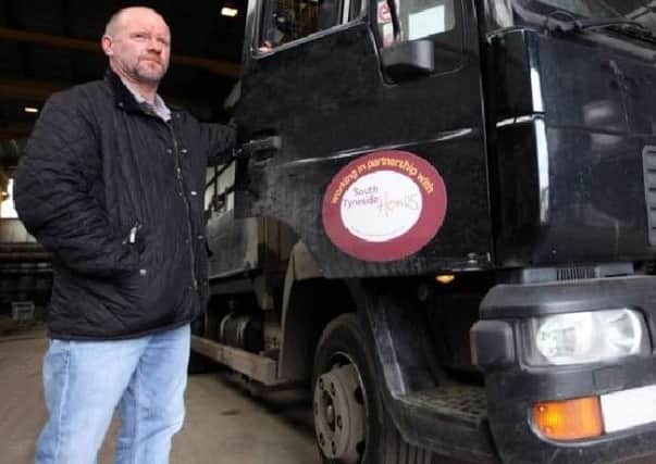 John Robertson with one of his trucks in 2011