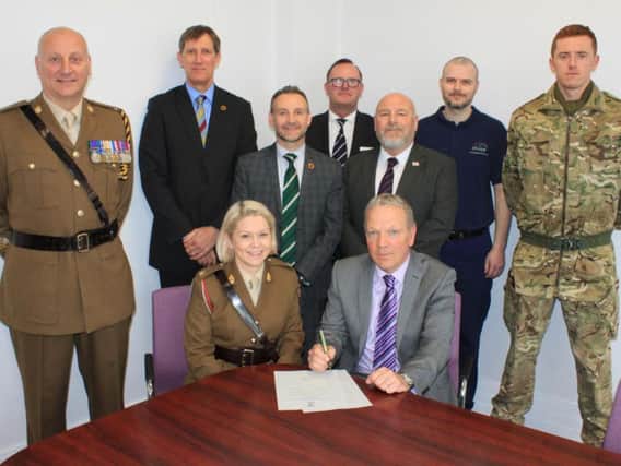 CHoICE Managing Director Ian Makinson signing the Armed Forces Covenant alongside Major Terry McDermott-Moses, with, left to right, Warrant Officer 1 Den Mustard, David Eccels, Gary McLafferty, Mark Stouph, Brian Hughes-Mundy, Mark Hope and Nathan Gibson.