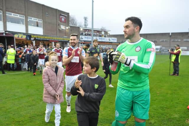 South Shields FC players and supporters take part in a minutes applause in memory of Jak Fada in December