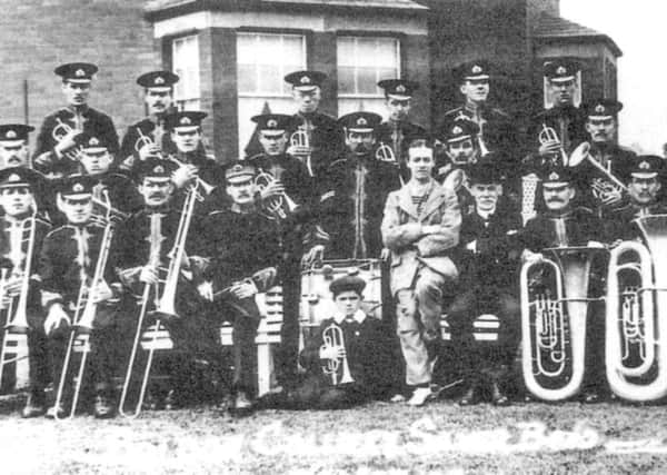 Members of Boldon Colliery Band, pictured three years after its formation, in the garden of the colliery manager's house on 30 May 1914.  The bandmaster was Tom Pick and the little boy at the front was Ignatius Ford.  The building  behind the fence (right) was part of Cold Sides Farm.