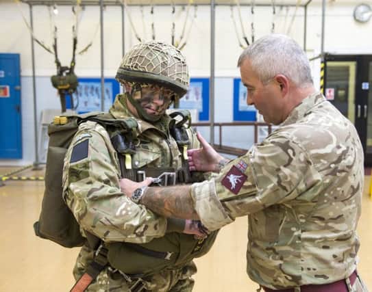 Sergeant Dave Walker having some parachute equipment checked.