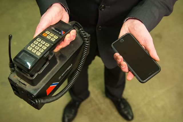 A member of staff holds a Motorola 500X car phone, left, and an Apple iPhone 6, which are among the items being held at the Transport for London Lost Property Office.
