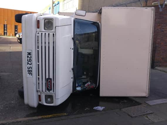 Removal van flipped on its side.