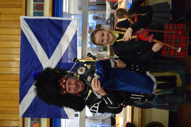 Bagpiper Ken Smith shows Grace Hewitt, from Year 5, how to play the bag pipes at Bede Burn Primary Schools Burns Day themed lunch.