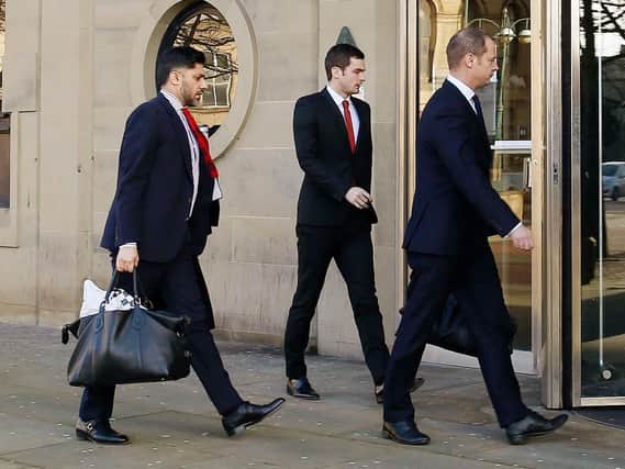 Footballer Adam Johnson (centre) arrives with unidentified men at Bradford Crown Court for the start of the defence at his trial where he is accused of sexual activity with a child. Photo credit: Peter Byrne/PA Wire