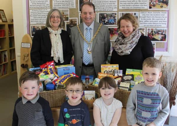 Youngsters hand over food donations after answering a call for help to boost stock at New Hope Churchs foodbank.