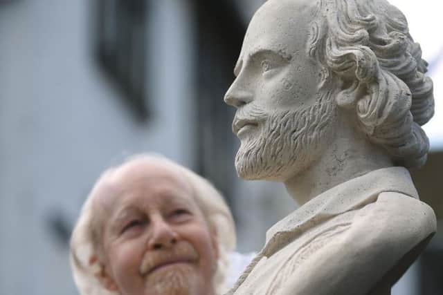 Re-enactor John Evans looks at a bust of William Shakespeare during the parade marking 400 years since the death of the playwright in Stratford-upon-Avon, Warwickshire.