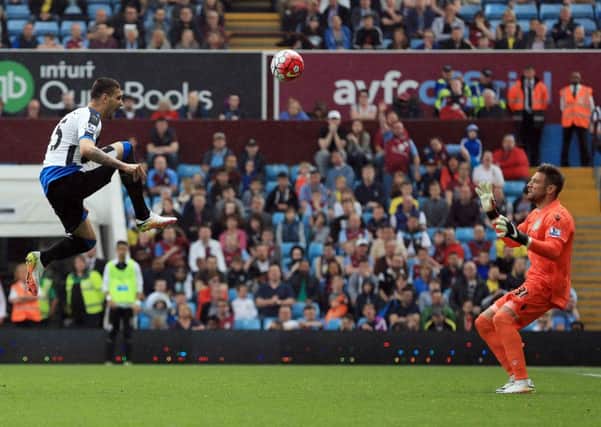 Newcastle Uniteds Aleksandar Mitrovic (left) lifts his shot over Aston Villa goalkeeper Mark Bunn.