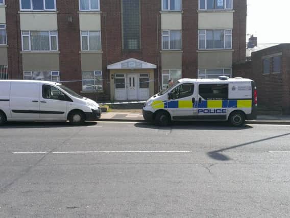 Police and forensics at the block of flats where a man's body was found.