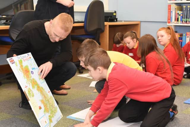 Matt Perry with Jarrow Cross Primary School pupils researching family history at Jarrow Library.