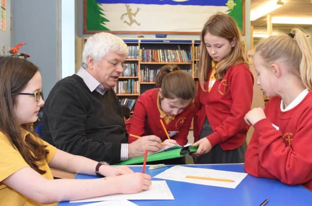 Tom Kelly with Jarrow Cross Primary School pupils researching family history at Jarrow Library.