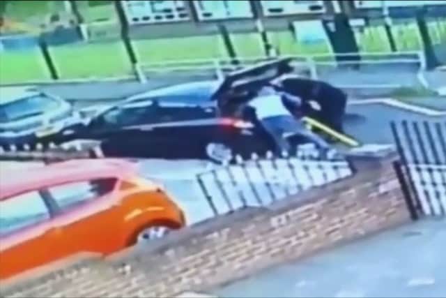 A still from the CCTV showing thieves taking tools from Kieran Maughan's car.