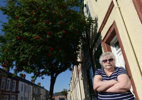 Kathleen Cann complaining about state of pavement outside her home casue by a tree.