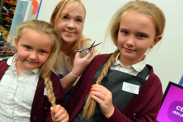 At Bamburgh School, there was a charity hair cut in aid of CLIC Sargent. From left, Maddie Gray, 5, with sister Holly Gray, 8, and hairdresser Katherine Daily.