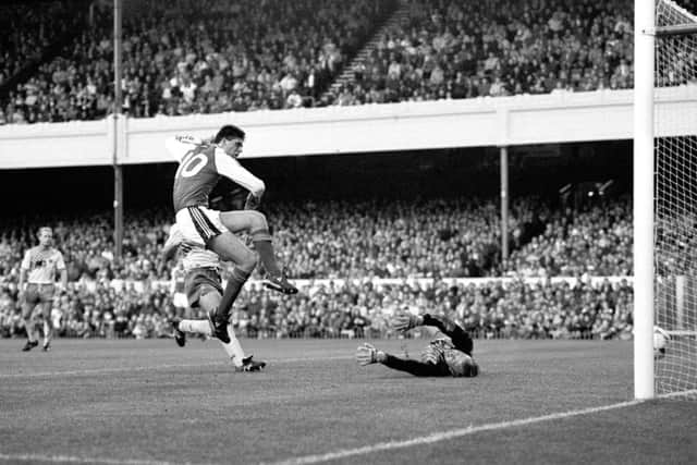 Then Arsenal player Niall Quinn guides the ball past Norwich City goalkeeper Bryan Gunn to score his team's first goal on November 4, 1989.