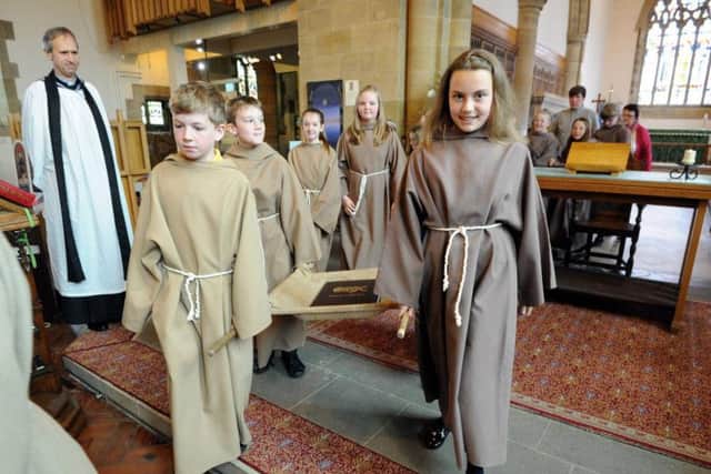 Pupils from Fulwell Primary School carry the Children's Codex out of St Peter's Church.