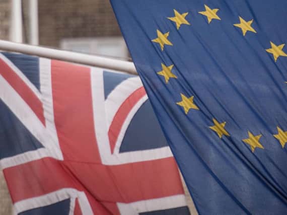 What are the two sides of the EU debate saying about the economic risks of staying or leaving?