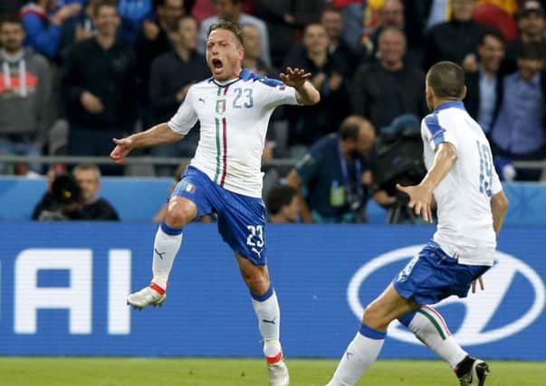 Italy's Emanuele Giaccherini, left, celebrates after scoring his side's first goal during the Euro 2016 Group E soccer match between Belgium and Italy at the Grand Stade in Decines-Charpieu, near Lyon, France, Monday, June 13, 2016. (AP Photo/Antonio Calanni)