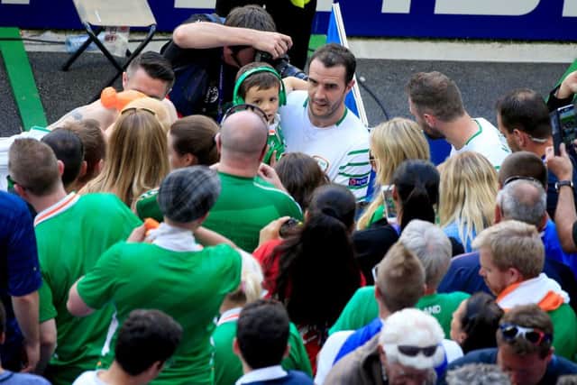 John O'Shea holds his son Alfie as he goes over to the fans after the defeat against France