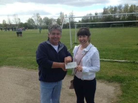 Malcolm Henzell's niece, Stephanie Burdis, presents the cheque to South Tyneside Football Trust charity manager Alan Millward.